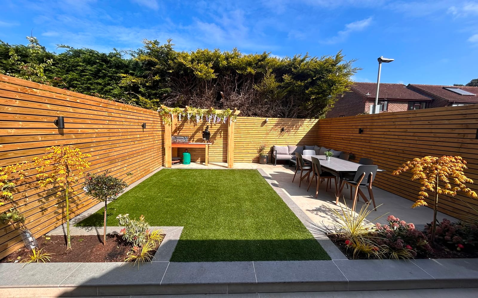 A finished natural stone patio with steps and a raised bed by Hills Driveways & Patios